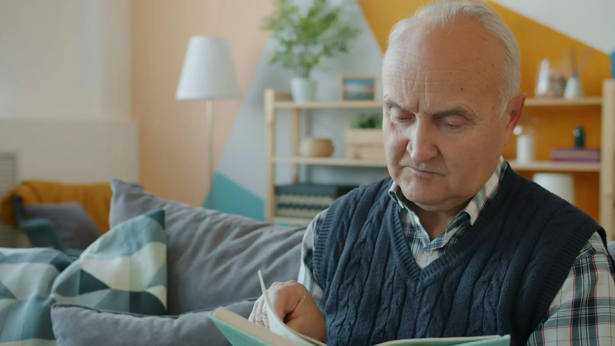 Older man reading at home during an aged care home visit