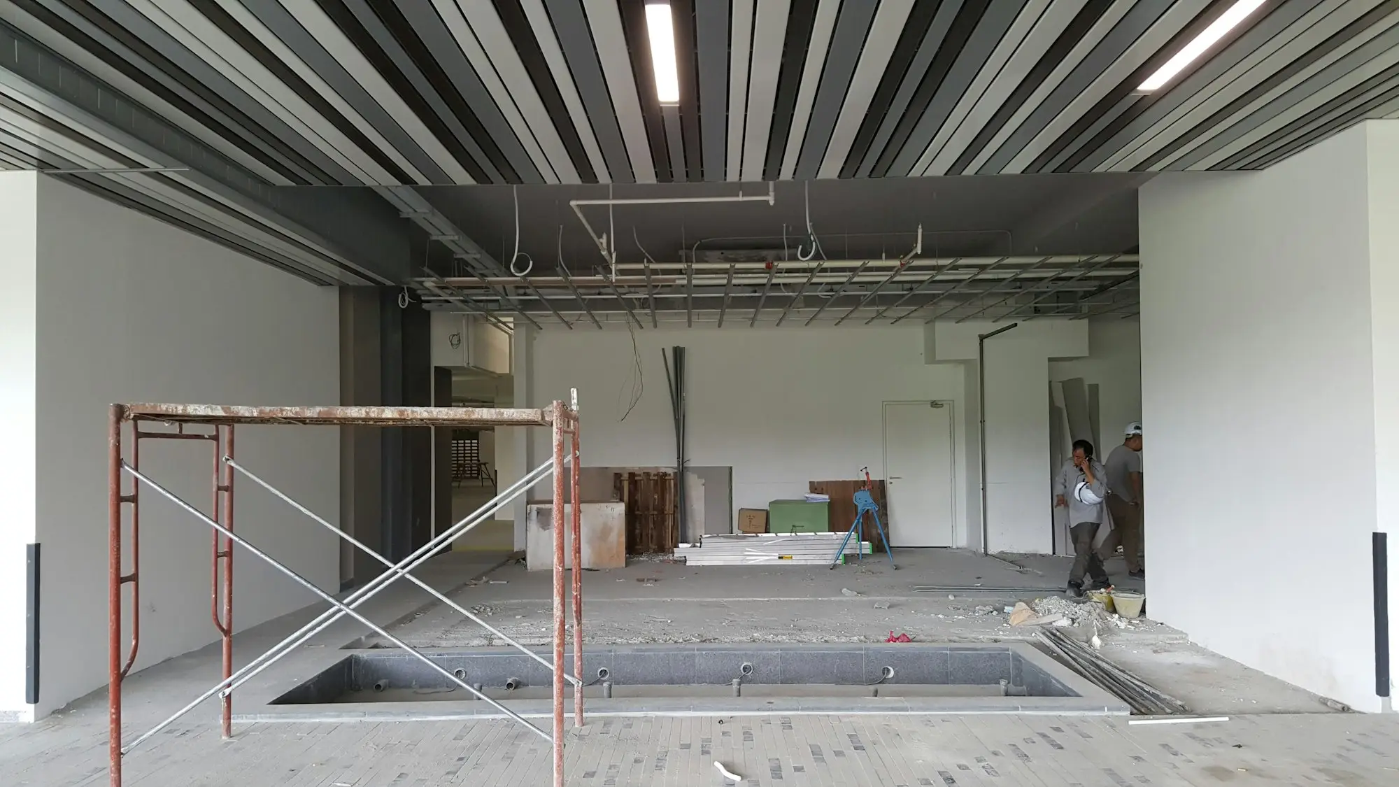 Commercial fit-out under construction with scaffolding inside an empty tenancy