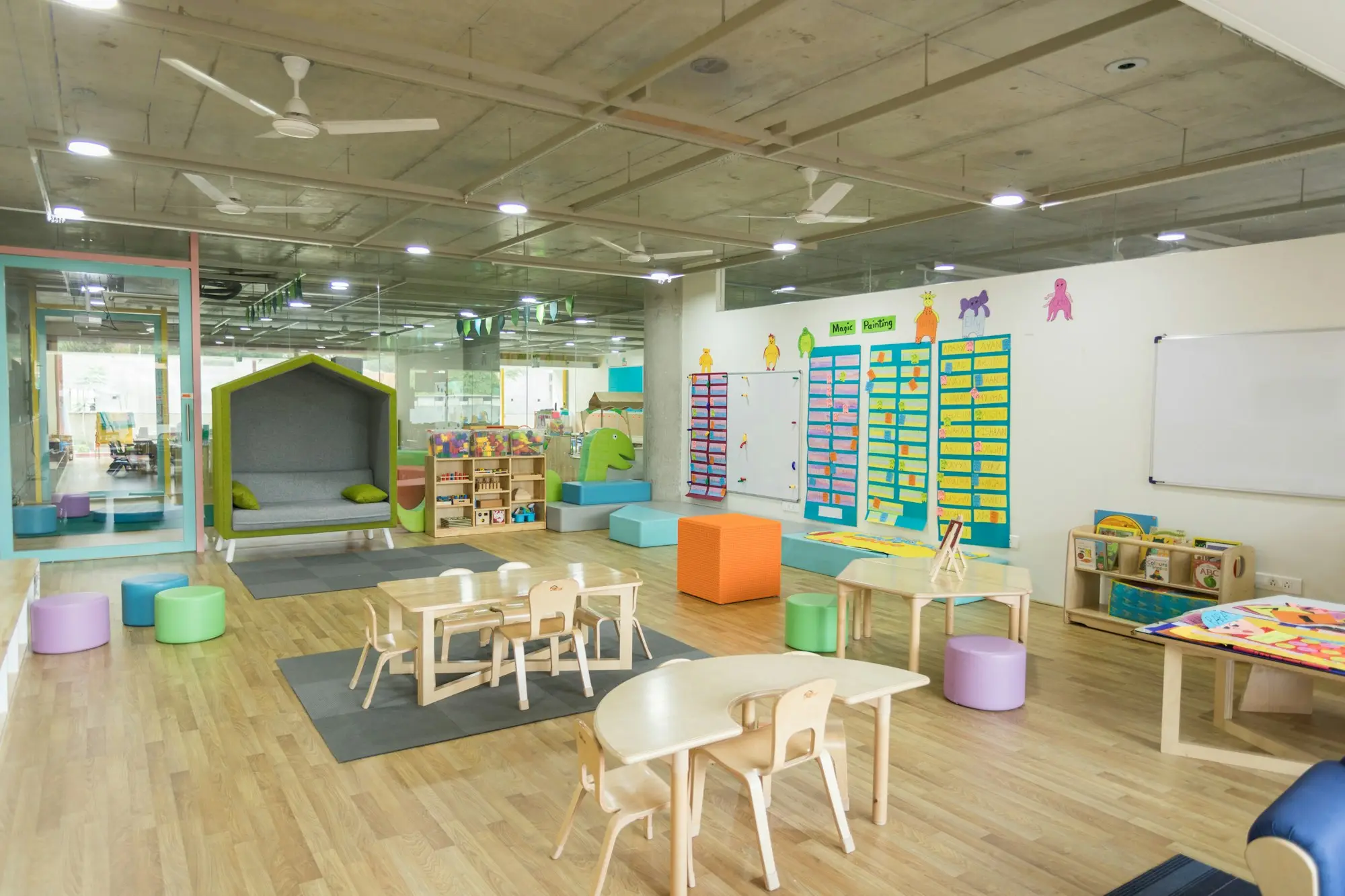 Empty early learning room with small tables, chairs and bright displays