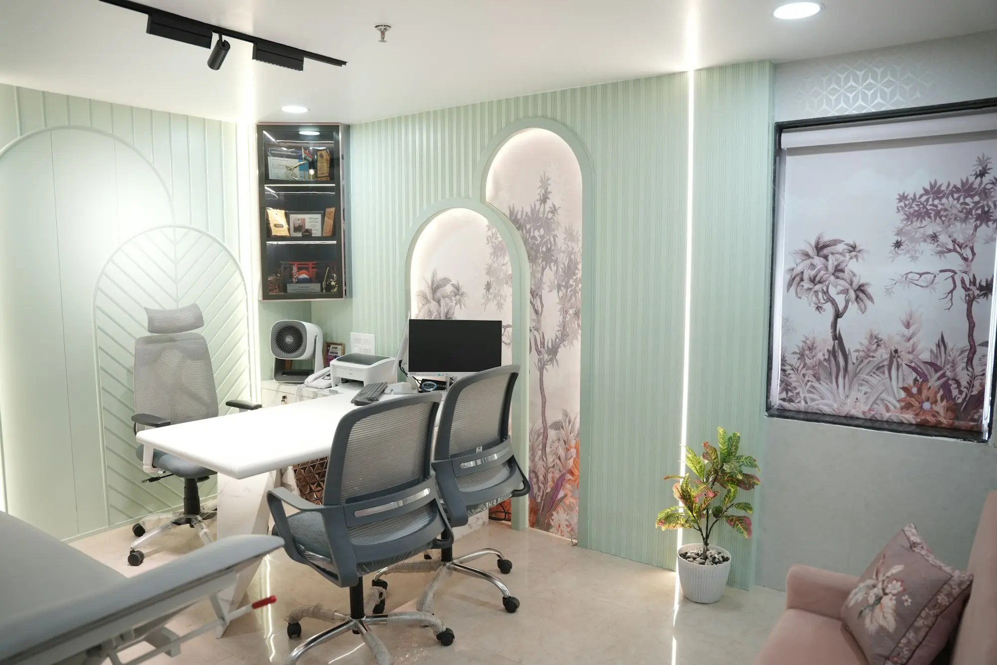 Bright medical clinic consulting room with desk, chairs and computer