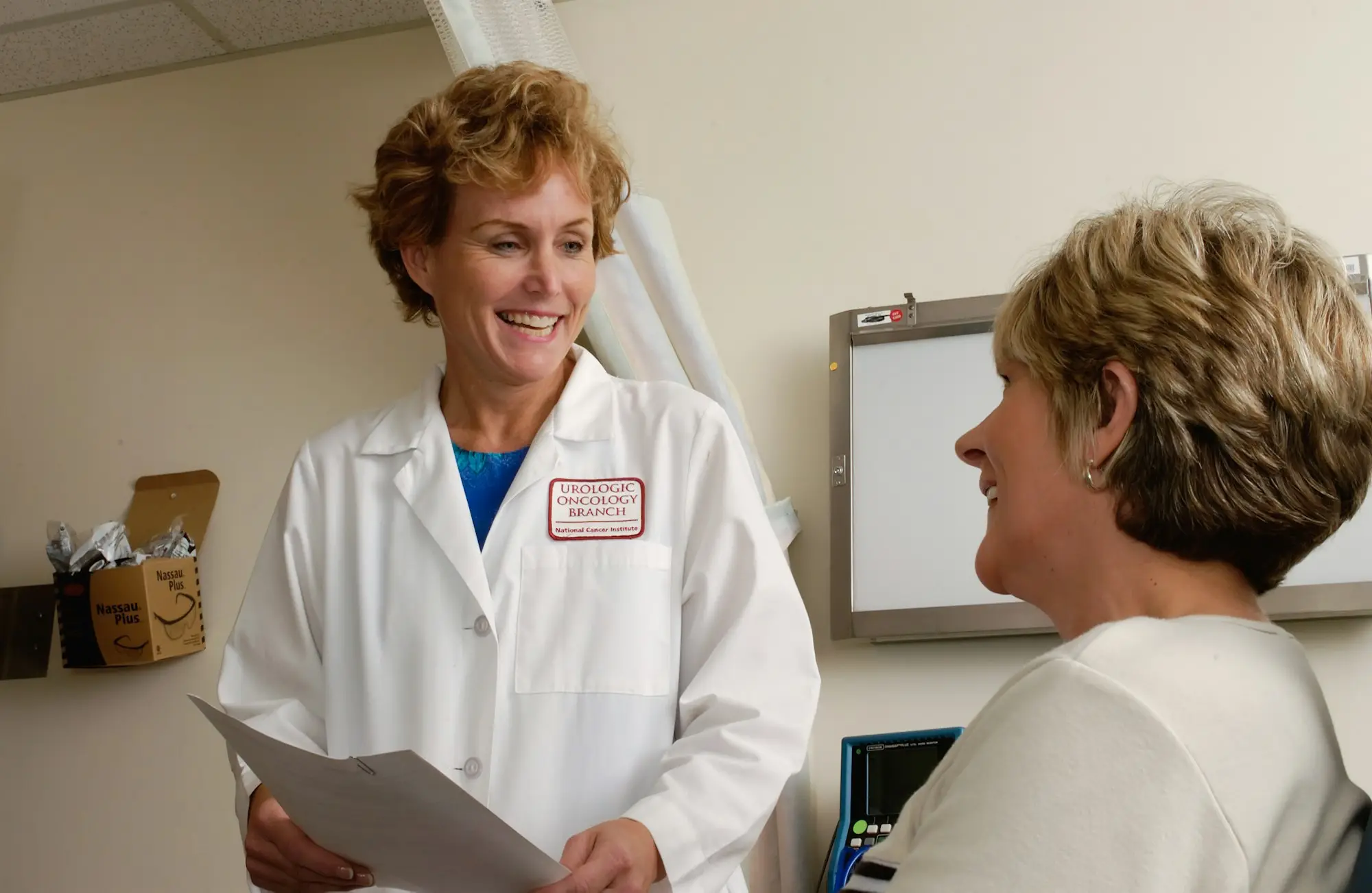 Doctor discussing paperwork with a colleague in a medical centre office
