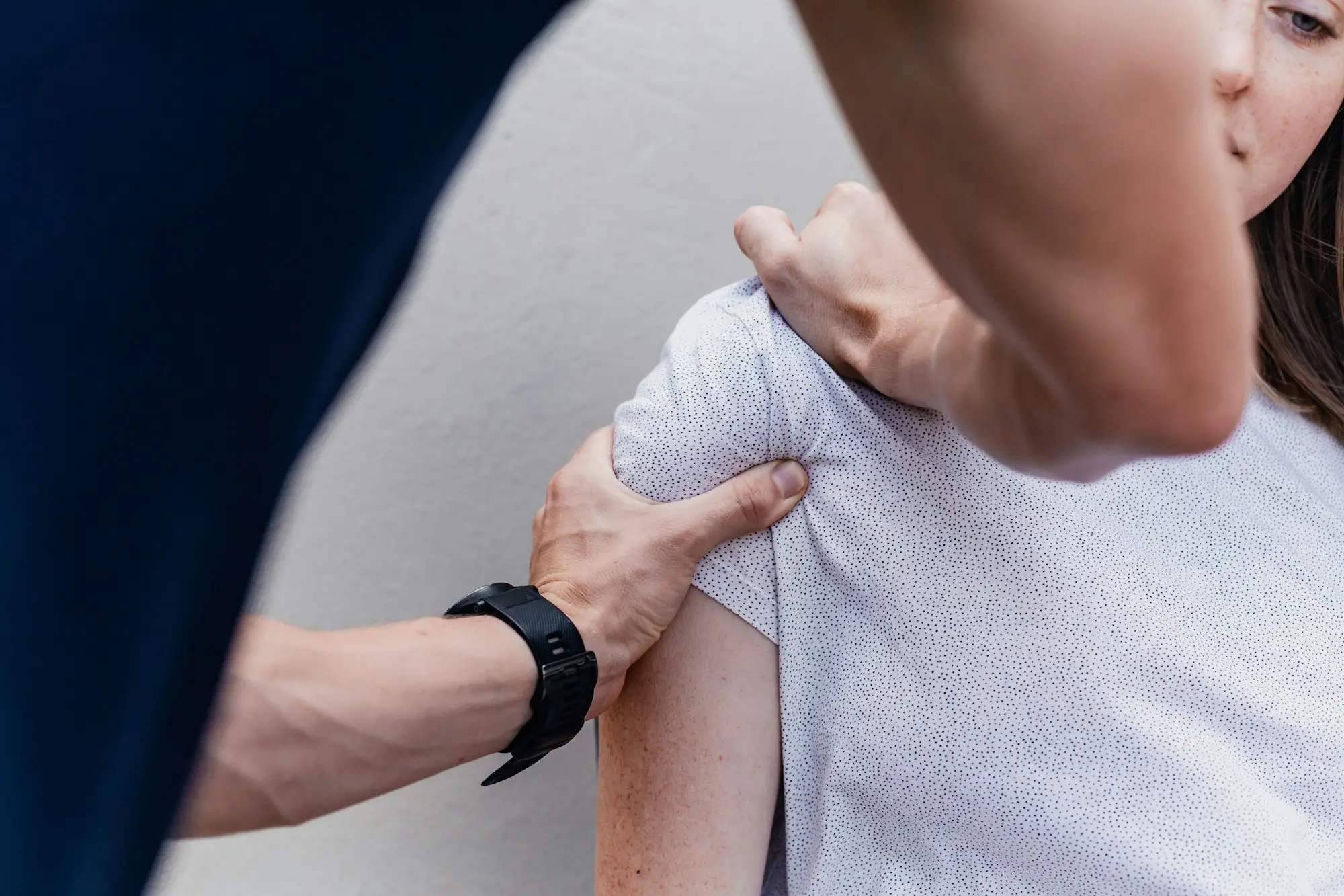 Physiotherapist treating a patient's shoulder in a clinic