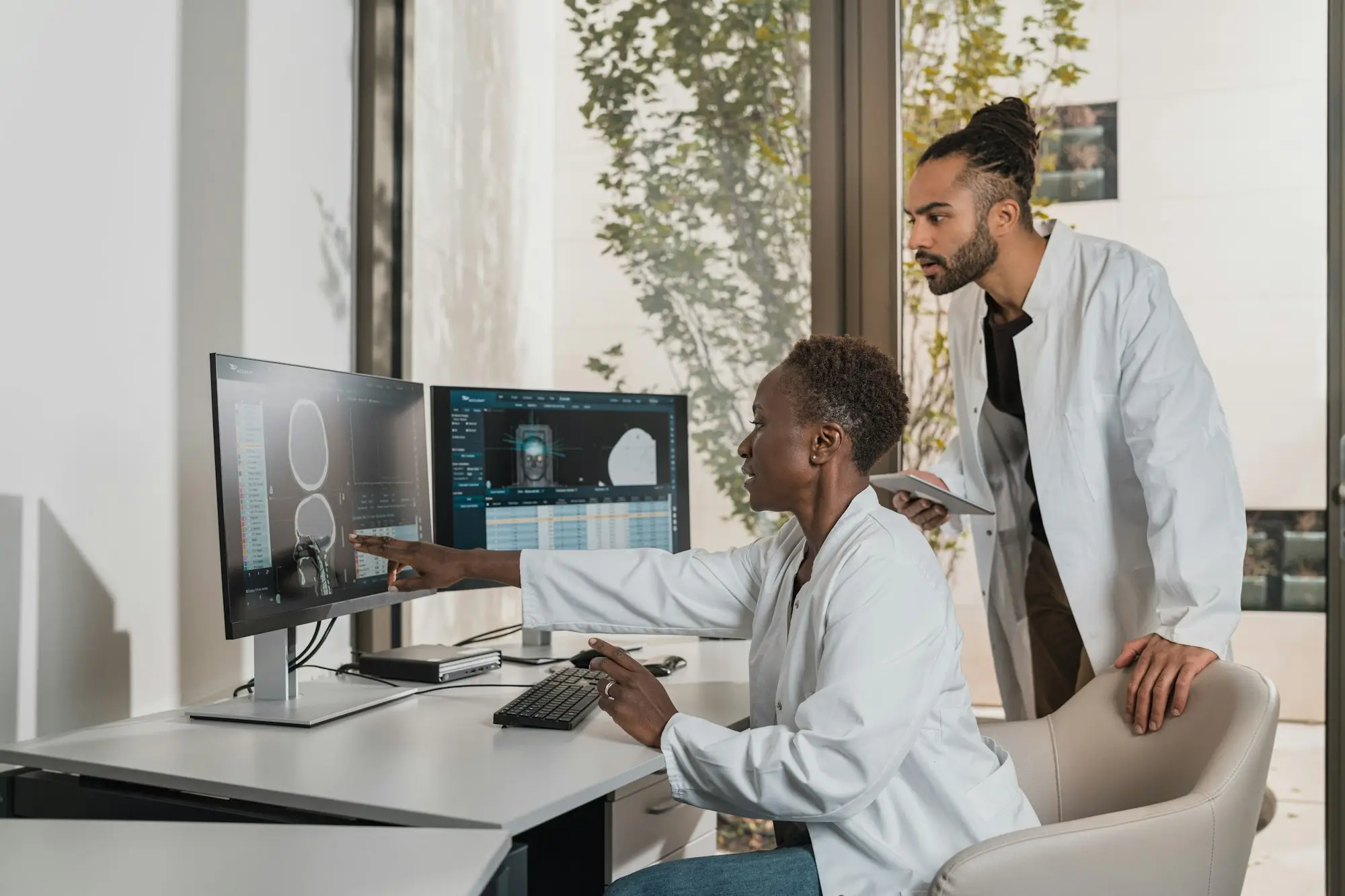 Specialists reviewing scans on monitors in a consulting room